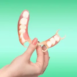 flexible nylon denture on female hand. Removable dentures flexible, devoid of nylon, hypoallergenic exempt from monomer